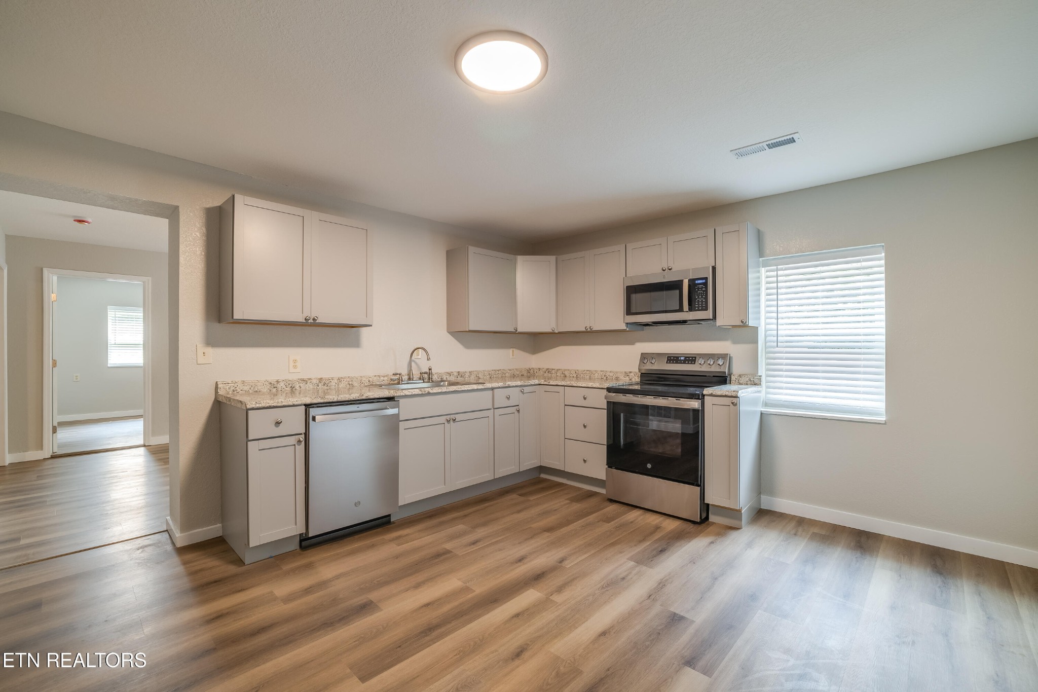 4707 Wildwood Road Maryville, TN 37804 - Photo 5 of 18 a kitchen with granite countertop a stove top oven and cabinets