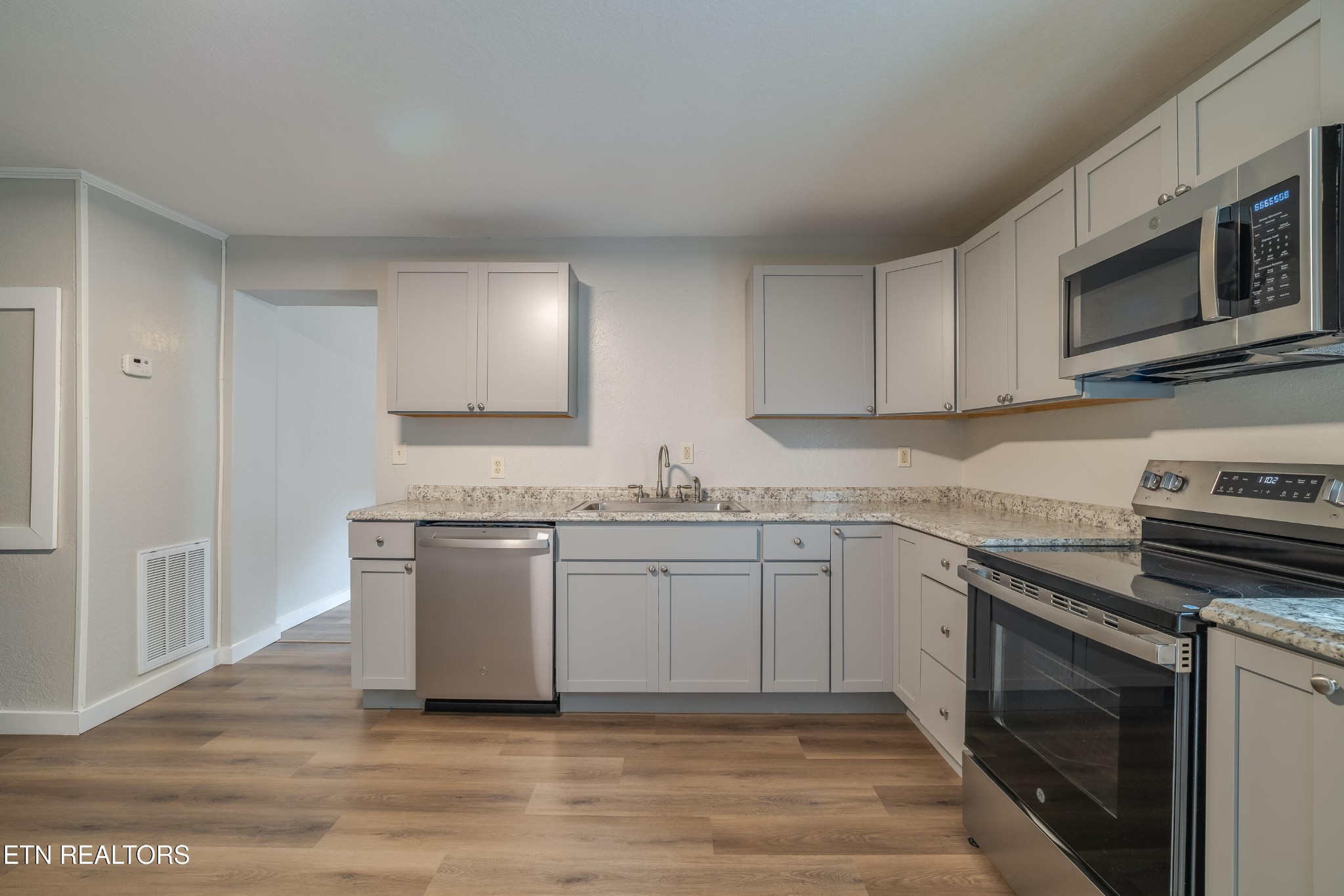 4707 Wildwood Road Maryville, TN 37804 - Photo 6 of 18 a kitchen with stainless steel appliances granite countertop a stove a sink and a microwave