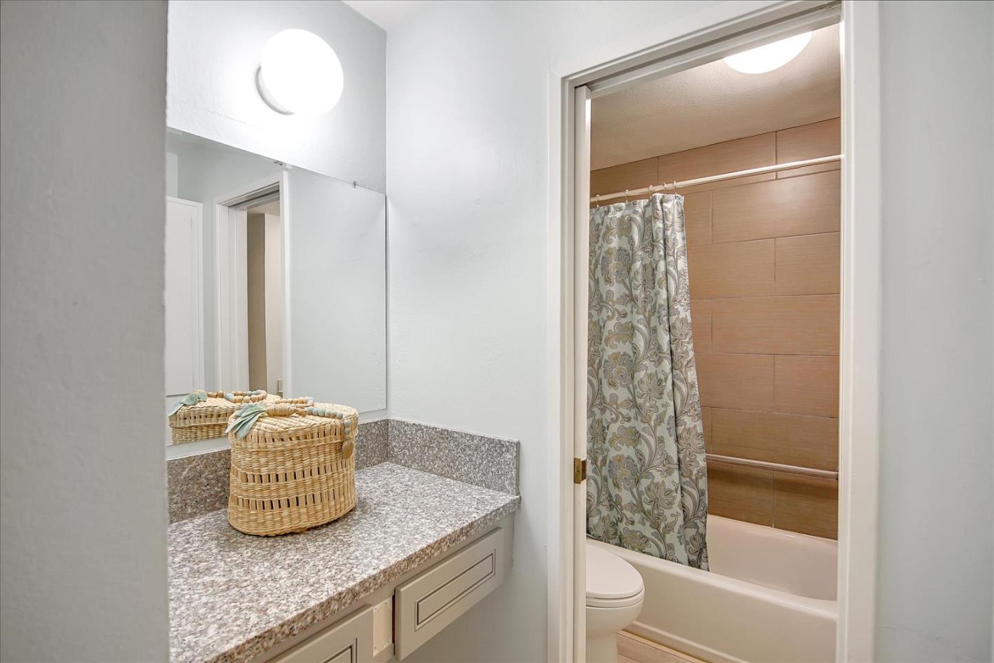 1925 46th Avenue, Unit 149 Capitola, CA 95010 - Photo 18 of 24 a bathroom with a granite countertop sink a toilet and shower