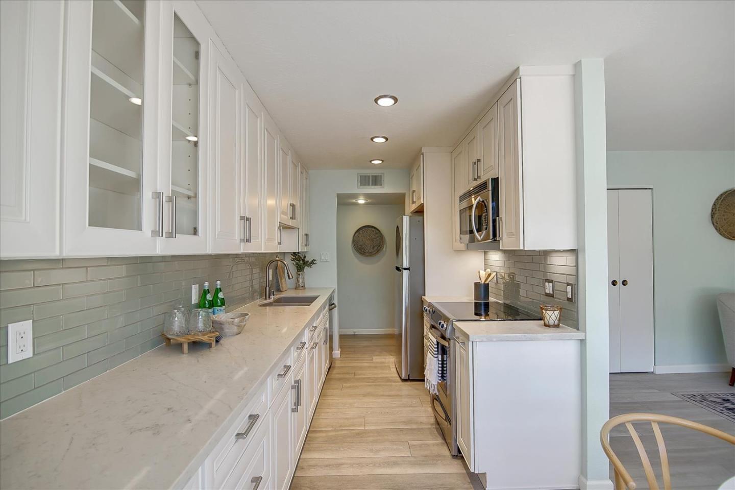 1925 46th Avenue, Unit 149 Capitola, CA 95010 - Photo 8 of 24 a kitchen with stainless steel appliances granite countertop a sink refrigerator and cabinets