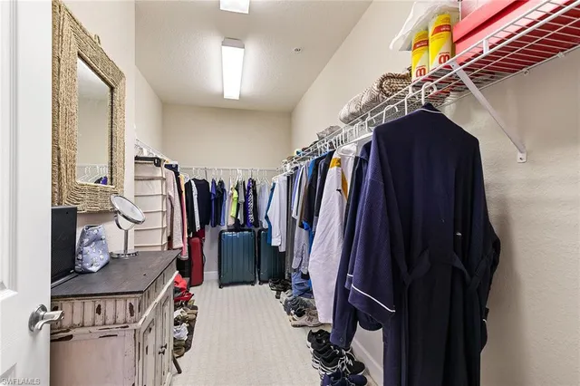 a view of walk in closet with clothes and shoes