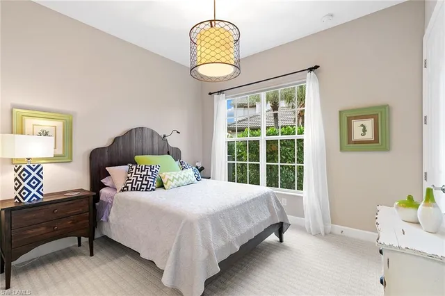 a bedroom with a bed chandelier and a window