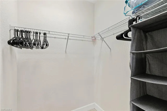 a view of walk in closet with clothes and shoes