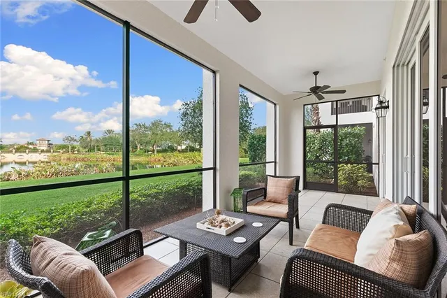 a living room with furniture and floor to ceiling windows