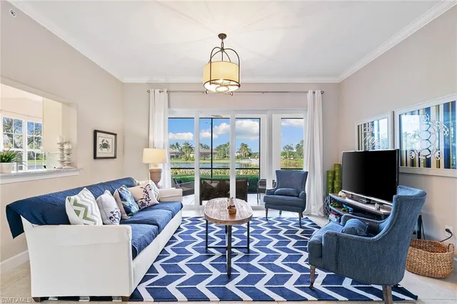 a living room with furniture a flat screen tv and a floor to ceiling window