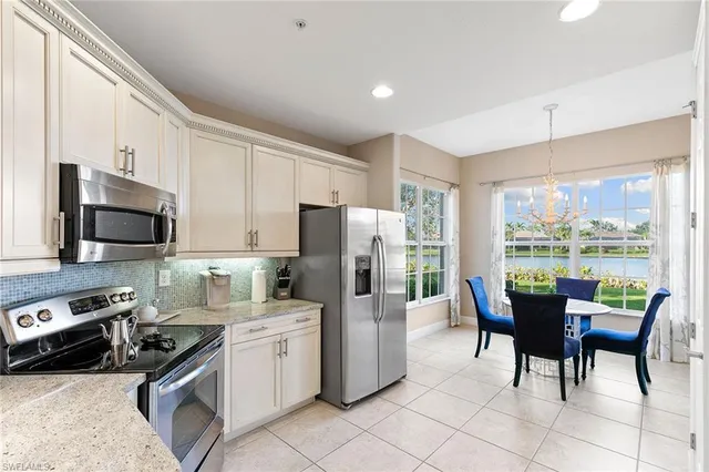 a kitchen with a table chairs microwave and refrigerator