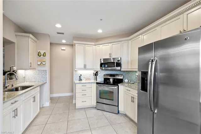 a kitchen with stainless steel appliances granite countertop a refrigerator and a sink