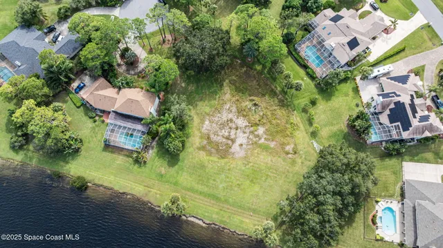 an aerial view of a residential houses with yard