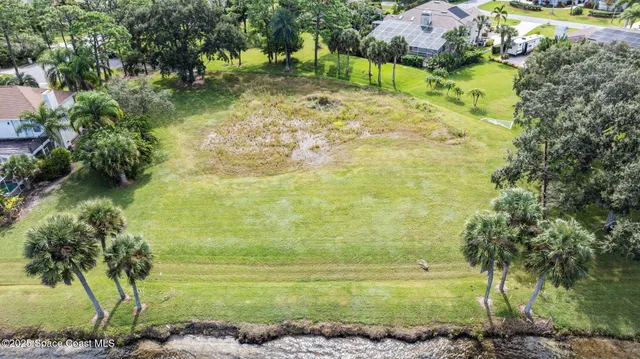 an aerial view of residential houses with outdoor space and lake view