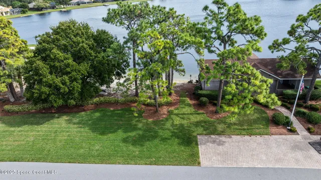 an aerial view of residential house with outdoor space and trees all around