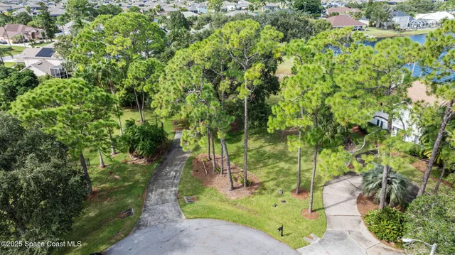 an aerial view of residential houses with outdoor space and trees
