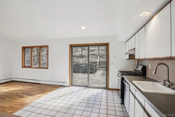 a kitchen with a sink a stove cabinets and a window