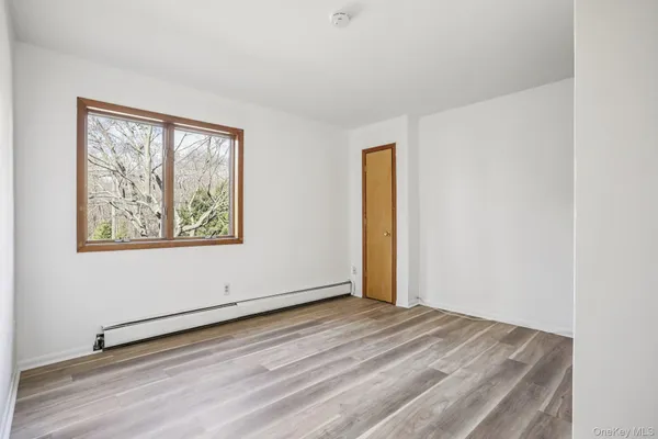 a view of a room with wooden floor and window