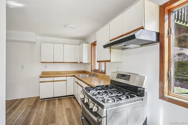 a kitchen with granite countertop a sink stove and cabinets