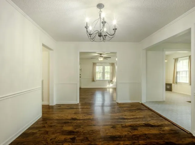 a view of empty room with wooden floor and window