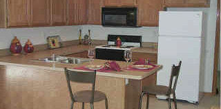 7280 North Alpine Road, Unit 2N Loves Park, IL 61111 - Photo 5 of 6 a kitchen with a table chairs stove and microwave