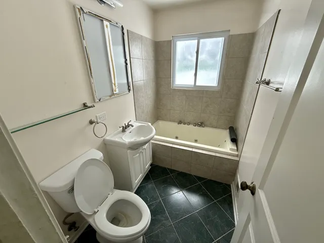 a white toilet sitting next to a bath tub