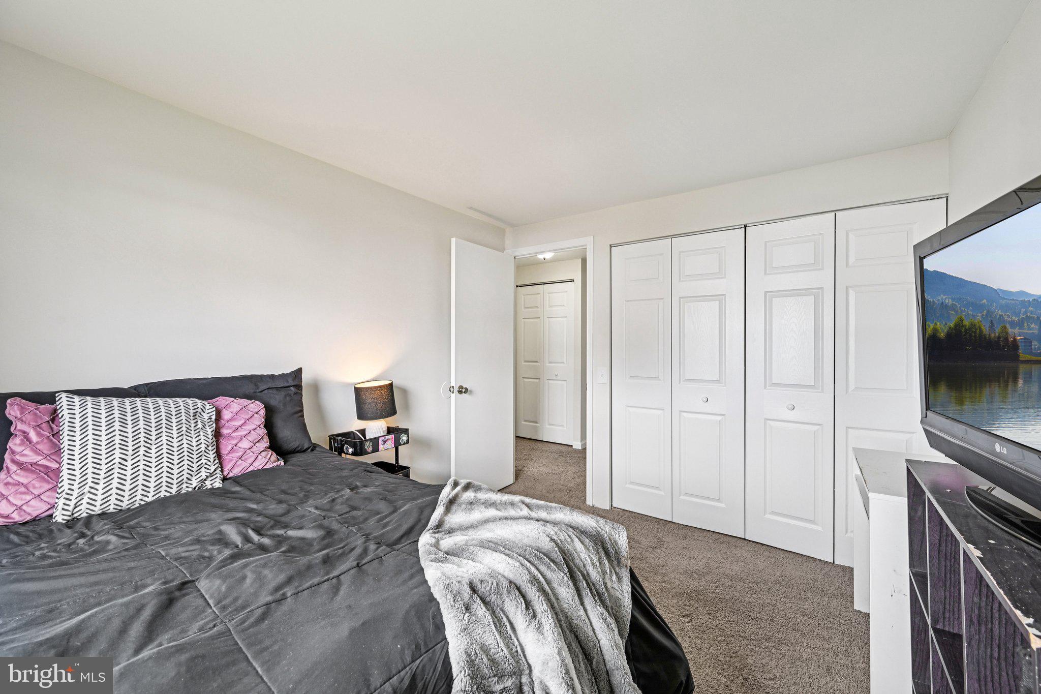 32 Coliston Road, Unit B Reisterstown, MD 21136 - Photo 18 of 24 a bedroom with a large bed and a flat tv screen on a dresser