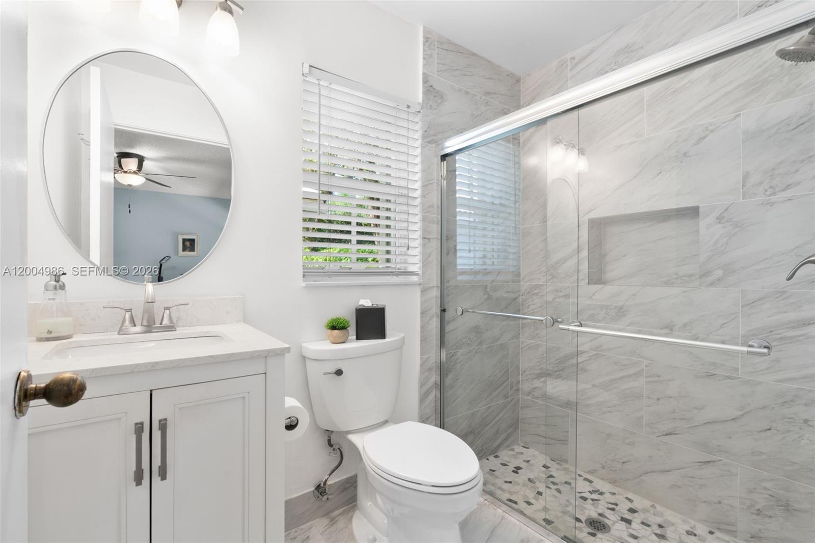 4108 Pine Ridge Lane Weston, FL 33331 - Photo 22 of 37 a bathroom with a toilet a sink a mirror a vanity and shower