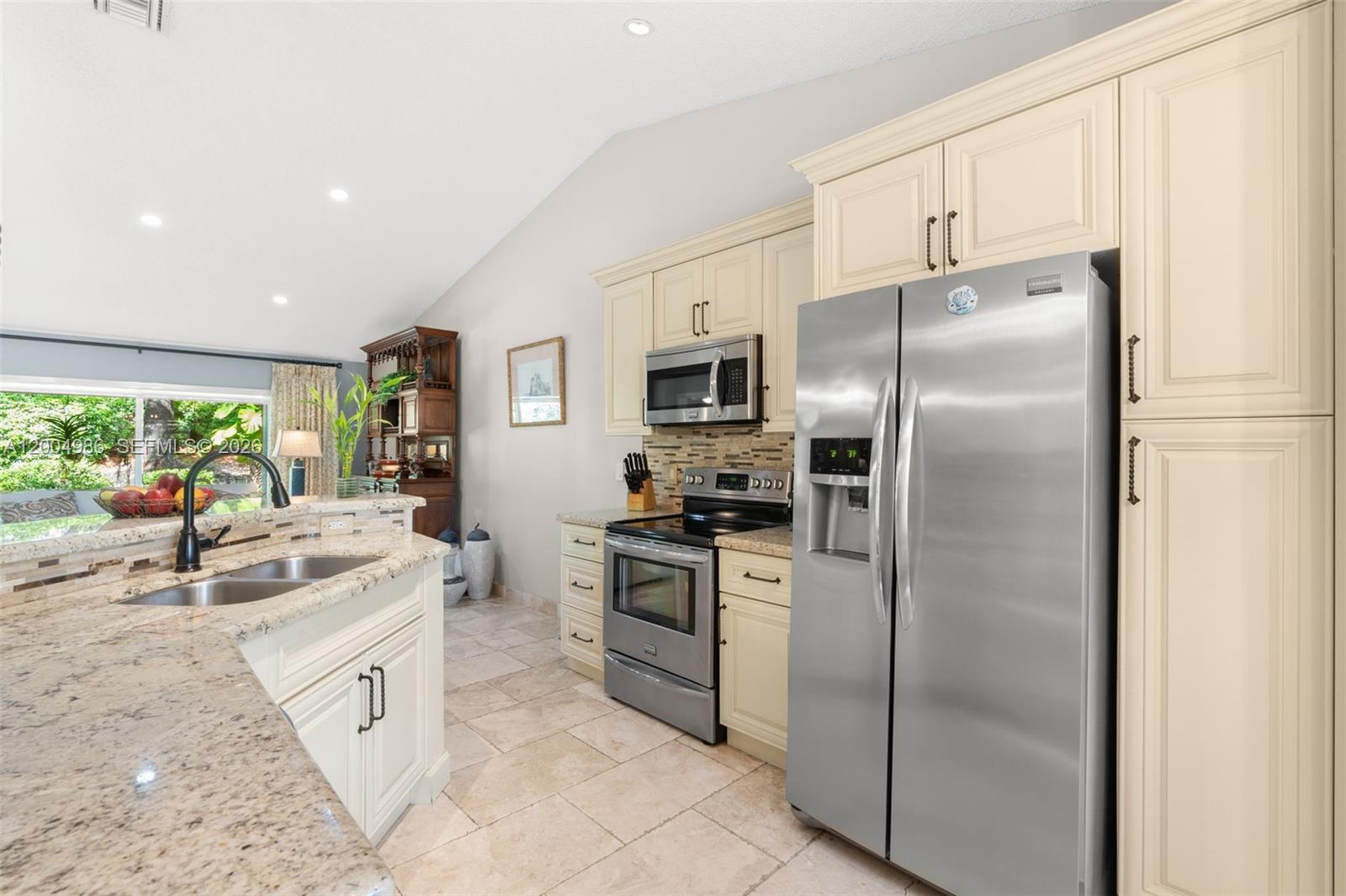 4108 Pine Ridge Lane Weston, FL 33331 - Photo 5 of 37 a kitchen with white cabinets and stainless steel appliances