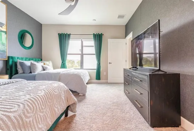 a bedroom with a bed window and mirror