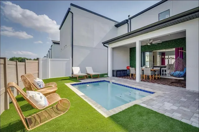 a view of a backyard with swimming pool table and chairs