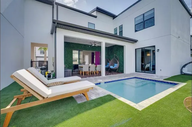 a view of pool with lawn chairs and couches