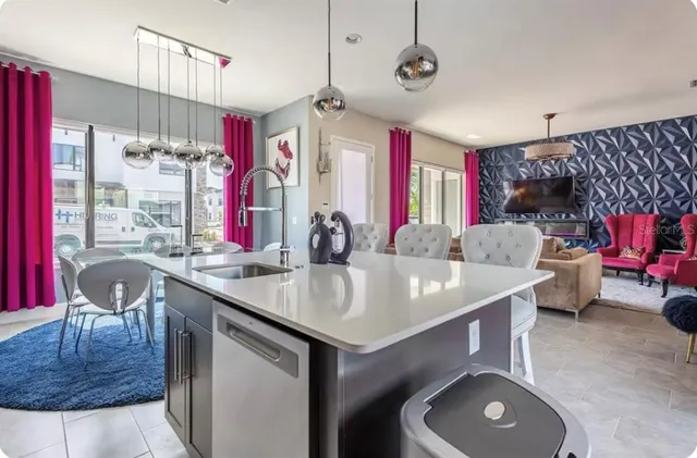 a view of kitchen island a sink and a chandelier