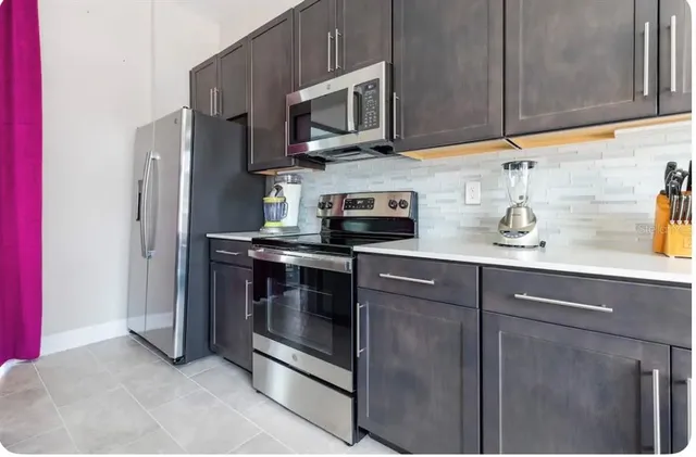 a kitchen with stainless steel appliances granite countertop a refrigerator and a stove top oven