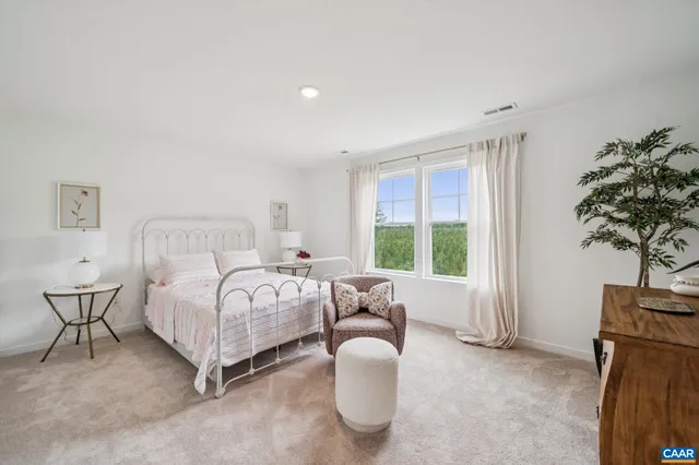a living room with furniture a rug and a floor to ceiling window