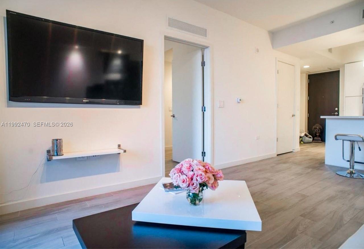 999 Southwest 1st Avenue, Unit 3208 Miami, FL 33130 - Photo 13 of 14 a living room with furniture and a flat screen tv