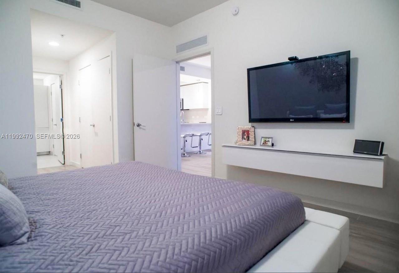 999 Southwest 1st Avenue, Unit 3208 Miami, FL 33130 - Photo 14 of 14 a bedroom with a bed and a flat screen tv