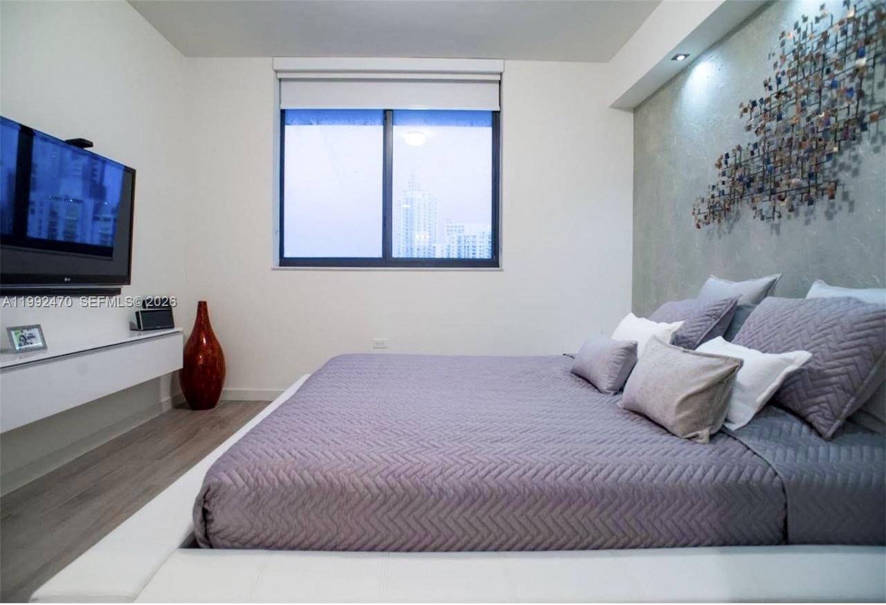 999 Southwest 1st Avenue, Unit 3208 Miami, FL 33130 - Photo 6 of 14 a bedroom with a bed and a flat screen tv