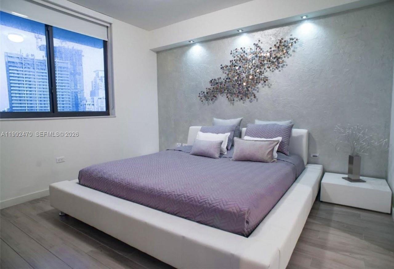 999 Southwest 1st Avenue, Unit 3208 Miami, FL 33130 - Photo 9 of 14 a bedroom with a bed and a potted plant