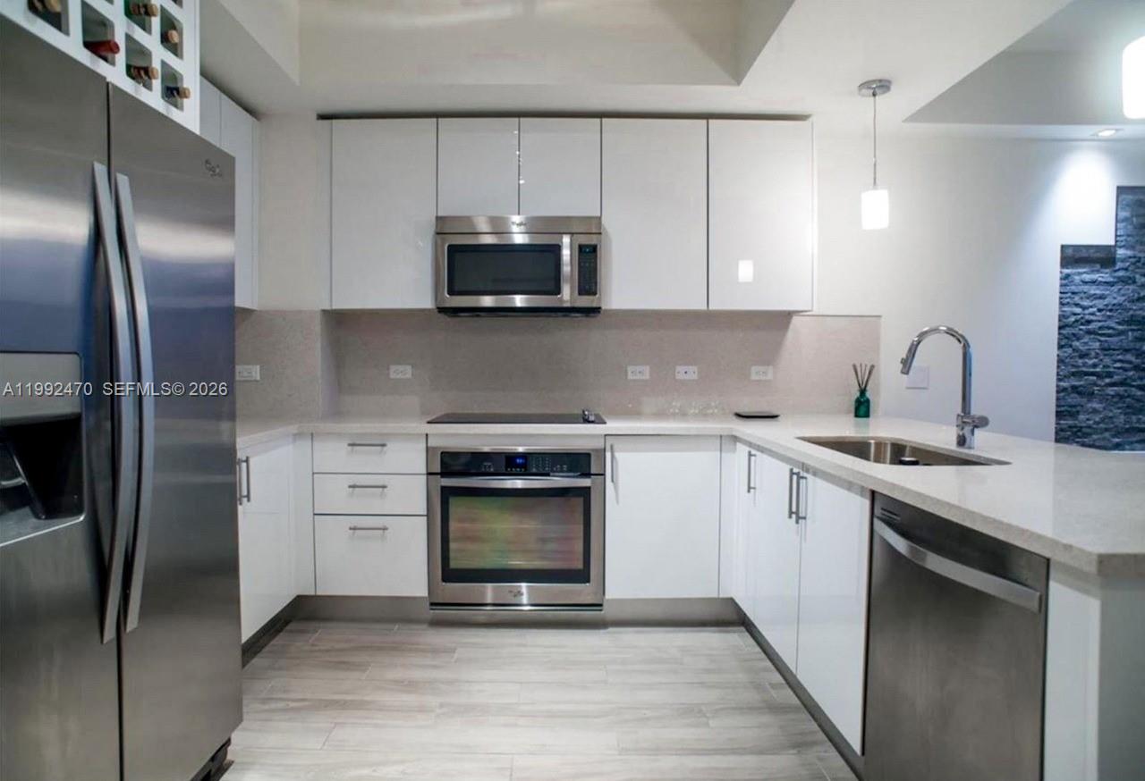 999 Southwest 1st Avenue, Unit 3208 Miami, FL 33130 - Photo 10 of 14 a kitchen with stainless steel appliances granite countertop a stove a sink and a refrigerator