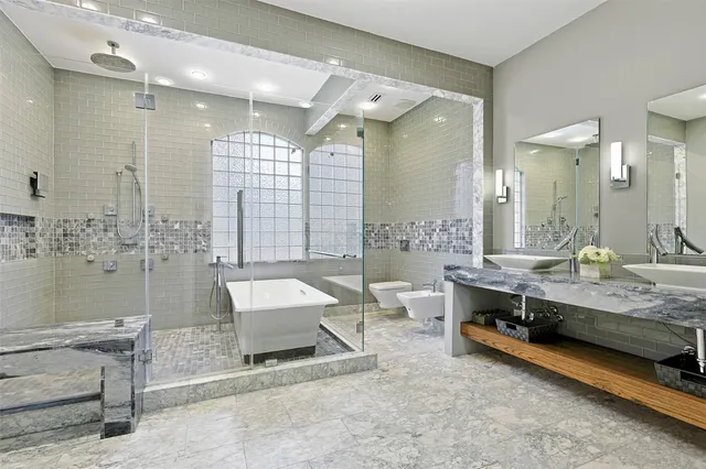 a spacious bathroom with a double vanity sink mirror and a bathtub
