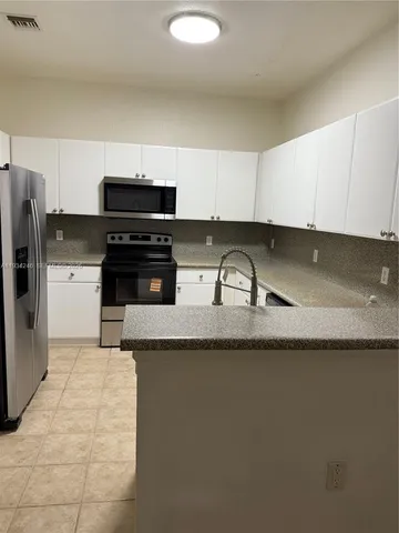 a kitchen with granite countertop a sink and a stove top oven