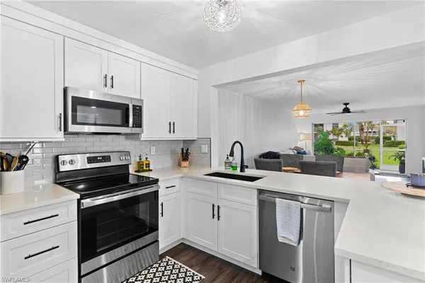 a kitchen with appliances a sink and cabinets