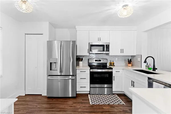 a kitchen with a sink stainless steel appliances and a counter space