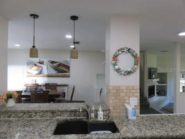 a kitchen with stainless steel appliances granite countertop a sink a stove and a wooden floors