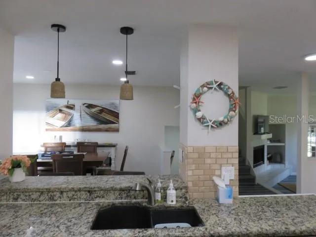 a kitchen with stainless steel appliances granite countertop a sink a stove and a wooden floors