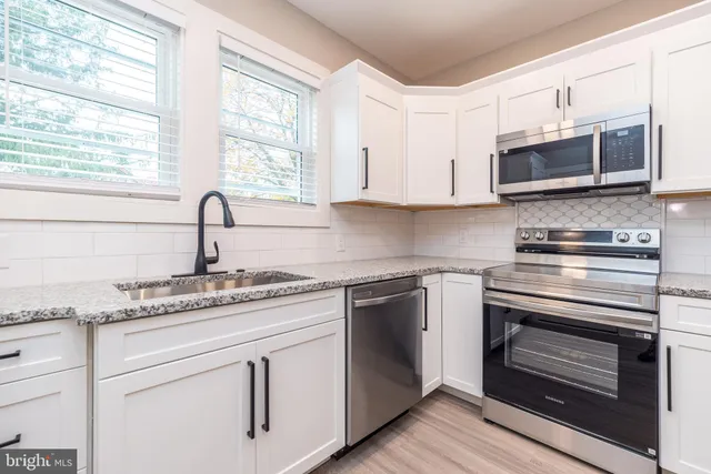 a kitchen with stainless steel appliances granite countertop a sink and a stove