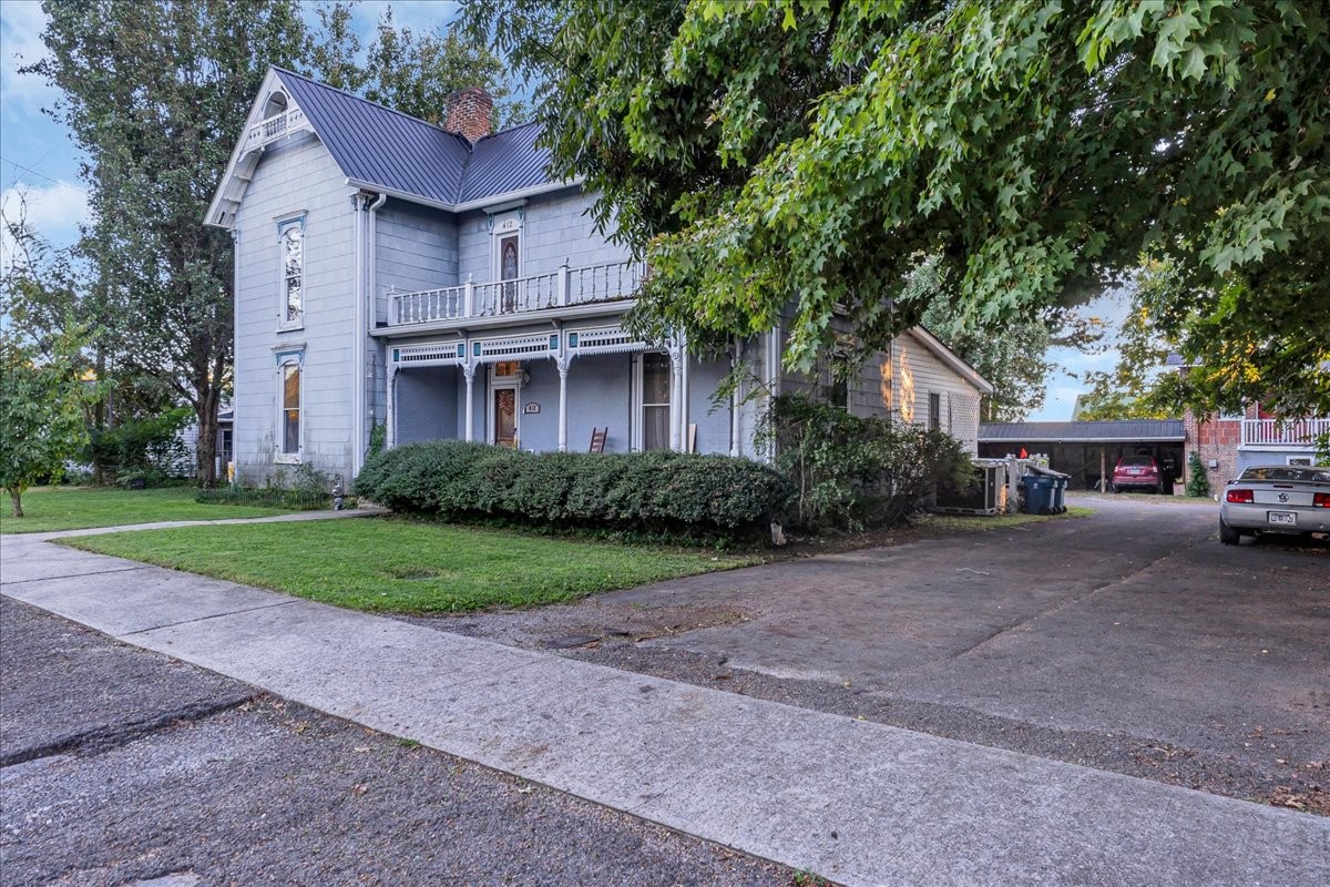 a front view of a house with a garden and trees