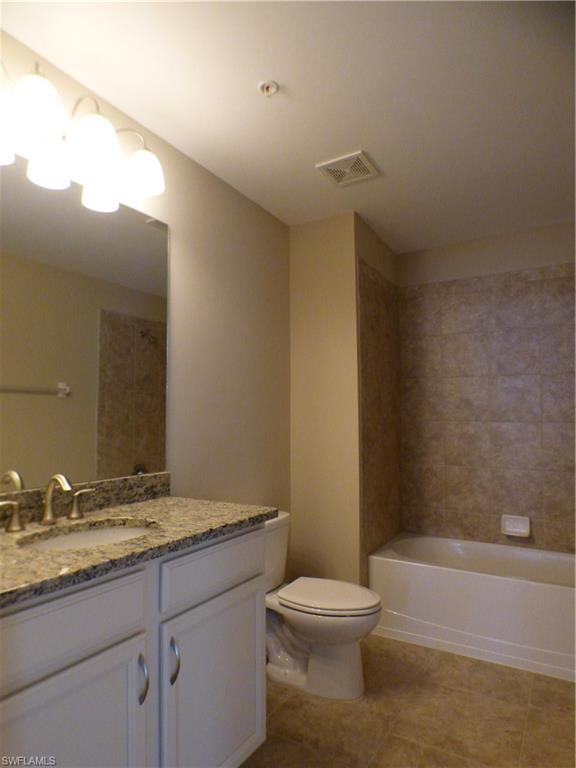 18244 Creekside Preserve Loop, Unit 102 Fort Myers, FL 33908 - Photo 12 of 23 a bathroom with a granite countertop sink a toilet and bathtub