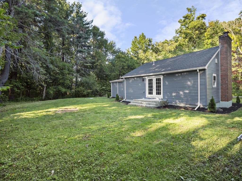 21 Webster Street Andover, MA 01810 - Photo 20 of 24 a backyard of a house with potted plants and large tree