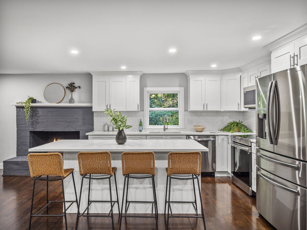 21 Webster Street Andover, MA 01810 - Photo 4 of 24 a kitchen with stainless steel appliances a dining table chairs refrigerator and sink