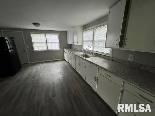 a view of a kitchen with a sink wooden floor and a window