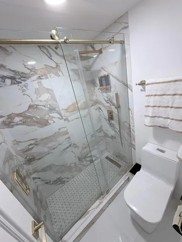 a bathroom with a toilet and a shower