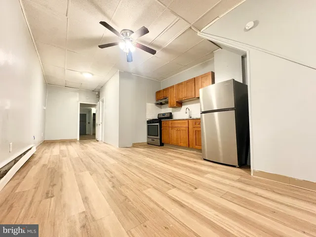 a view of empty room with wooden floor and ceiling fan