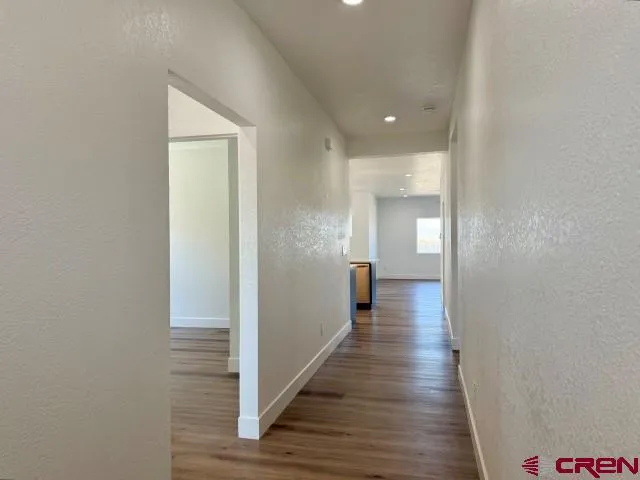 a view of a hallway with wooden floor